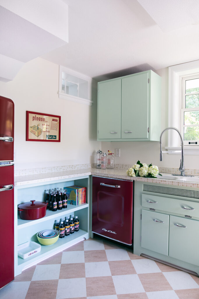 Mint green cabinets in retro kitchen design with red appliances.